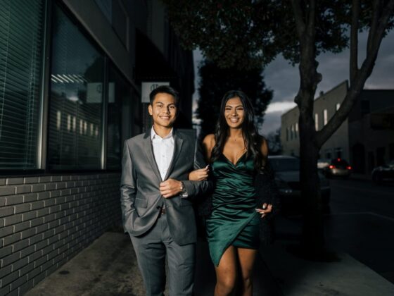 man in gray suit standing beside woman in green dress