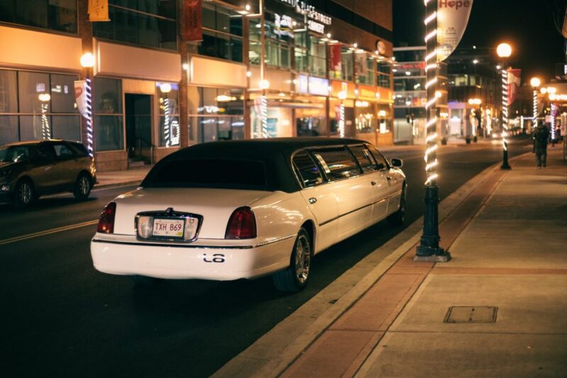 modern limousine on road with shiny lights in night town