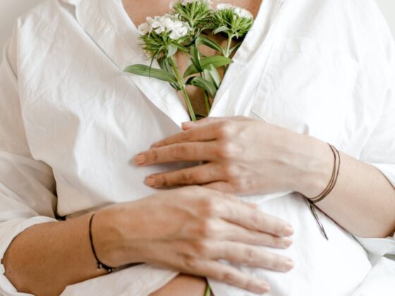 crop pregnant woman with blooming flower bouquet